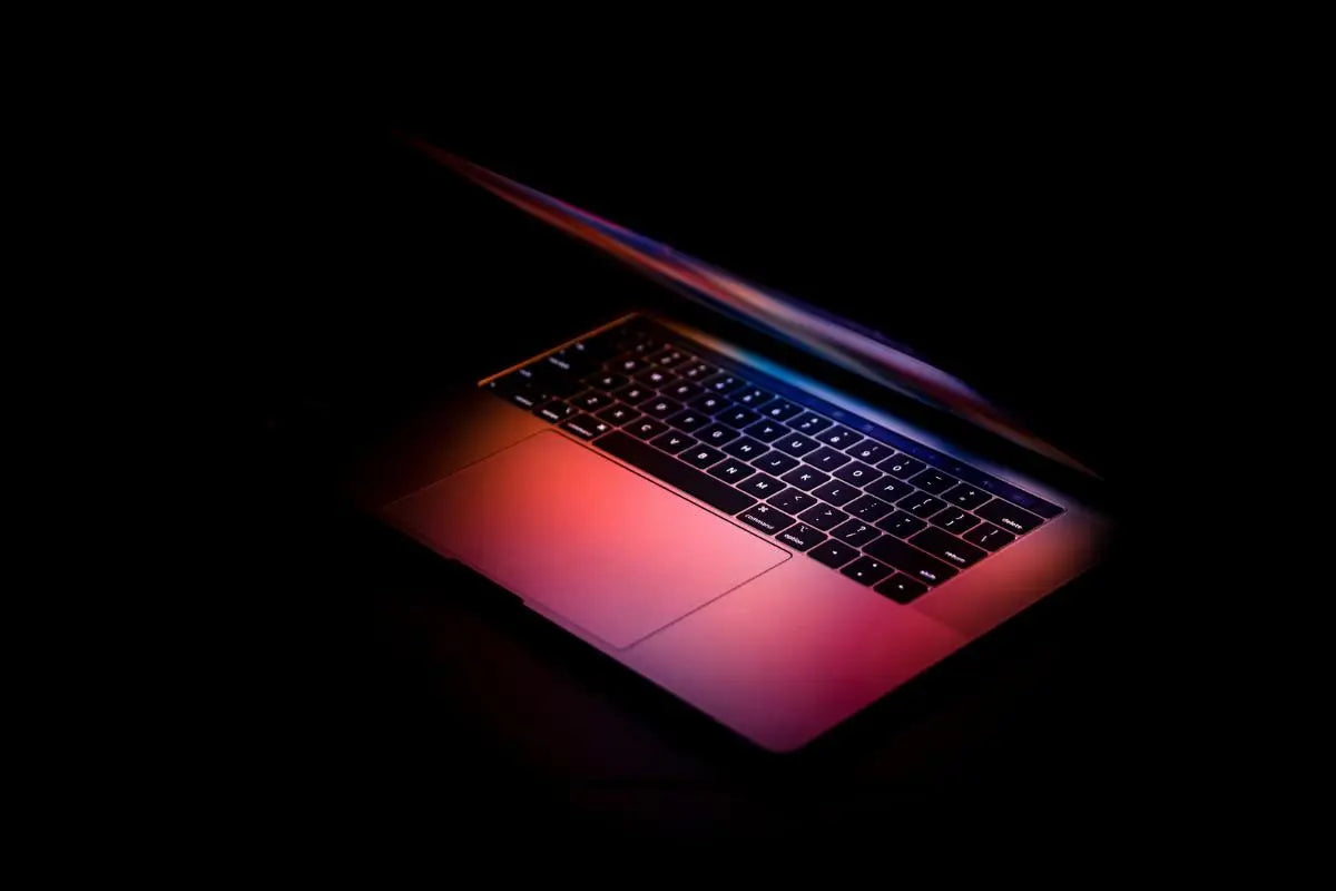 A glowing laptop in a dark workspace representing North Ember’s expertise in digital management, optimization, and technology-driven business growth.