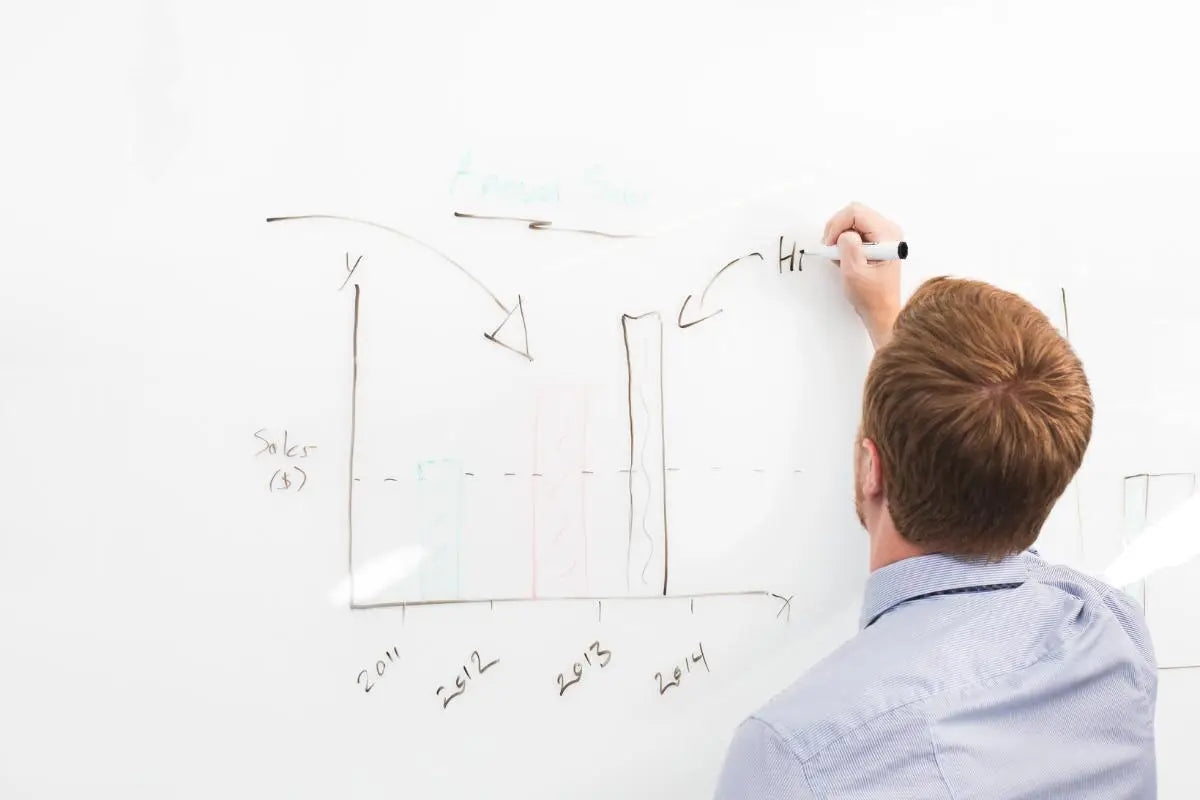 Consultant drawing strategy on a whiteboard chart representing North Ember’s data-driven marketing consulting, creative planning, and digital campaign development.